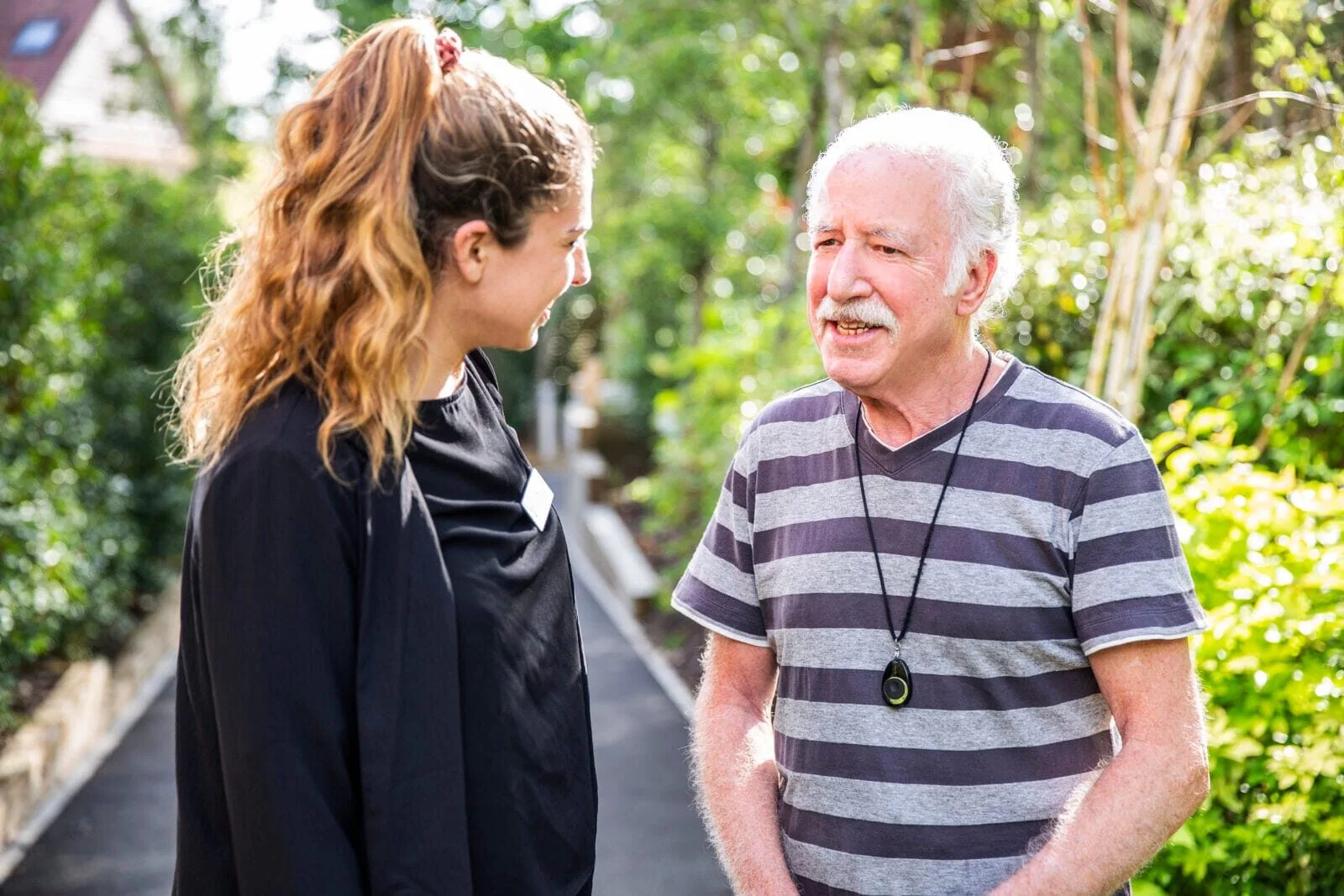 A carer and resident in the grounds at Kings Lodge