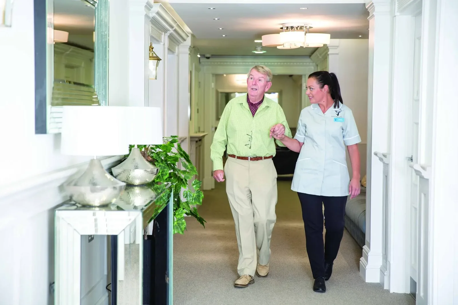 A member of the team walking arm in arm with a resident at Stratton Court